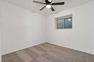 Carpeted bedroom featuring baseboards and ceiling fan