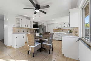 Dining area featuring light tile patterned floors and a ceiling fan