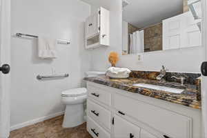 Bathroom with a shower with shower curtain, vanity, and light tile patterned floors
