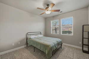 Carpeted bedroom featuring baseboards and a ceiling fan