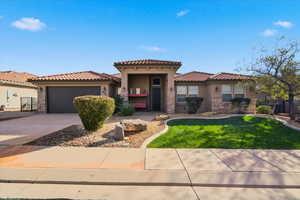 Mediterranean / spanish-style home featuring stone siding, stucco siding, a garage, and driveway