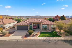 Mediterranean / spanish-style home featuring stone siding, concrete driveway, stucco siding, a garage, and a porch