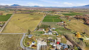Aerial view of property's location with rural landscape, a mountainous background, and farmland
