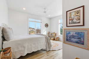 Bedroom with light wood-style floors, recessed lighting, and ceiling fan