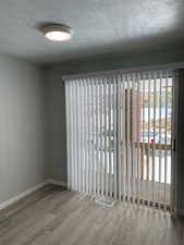 Spare room with a textured ceiling and wood finished floors