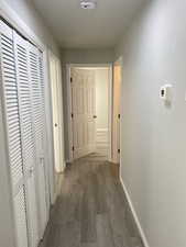 Hallway featuring dark wood finished floors and baseboards