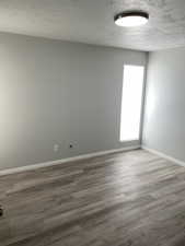Spare room with a textured ceiling and wood finished floors