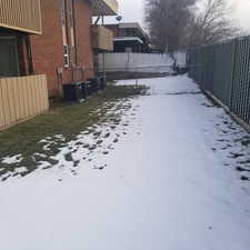 Yard covered in snow featuring a balcony