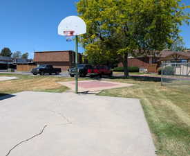 Outdoor concrete basketball court with a white backboard and red hoop