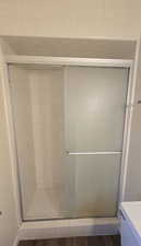 Bathroom with a stall shower and dark wood-style floors