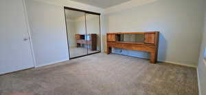 Unfurnished bedroom with a closet and carpet floors