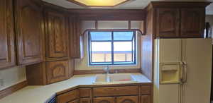 Kitchen with white fridge with ice dispenser and light countertops