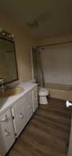 Full bathroom with vanity, shower / bath combination with curtain, and dark wood finished floors