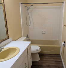 Full bath featuring vanity, dark wood-style floors, and shower / washtub combination