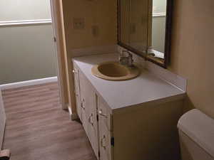 Half bath featuring vanity, dark wood-type flooring, and a textured ceiling