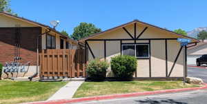 Exterior featuring a light-colored stucco finish with dark brown decorative trim and a dark brown window frame