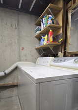 Washroom featuring separate washer and dryer and concrete flooring