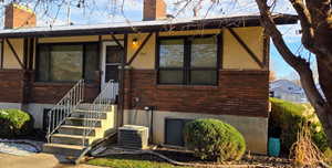 View of exterior entry with brick siding and a chimney