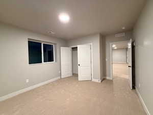 Unfurnished bedroom with light colored carpet and a closet