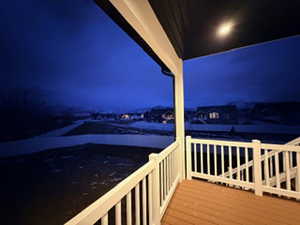 Deck at night featuring a balcony