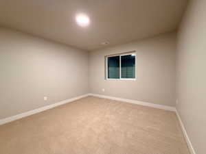 Unfurnished room featuring light colored carpet and baseboards