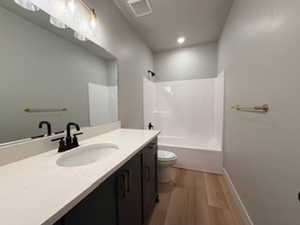 Bathroom with vanity, shower / bathtub combination, and light wood finished floors