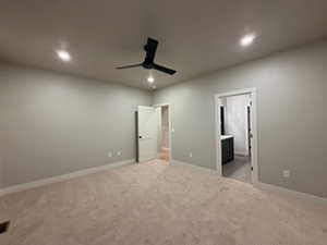 Unfurnished bedroom with light carpet, ceiling fan, ensuite bath, and recessed lighting
