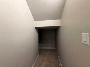 Hallway featuring baseboards and a textured ceiling