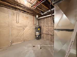 Unfinished basement featuring secured water heater and heating unit