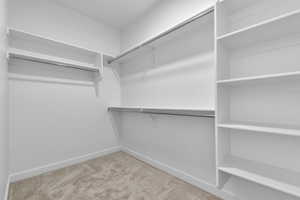 Walk in closet with light carpet