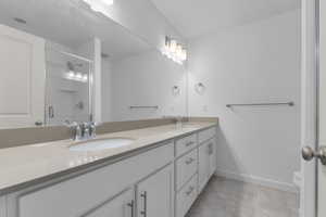 Bathroom featuring a shower stall and double vanity