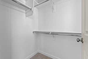 Walk in closet featuring light colored carpet