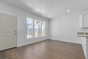 Unfurnished living room featuring dark wood finished floors and recessed lighting