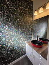 Bathroom with dark tile patterned flooring and vanity