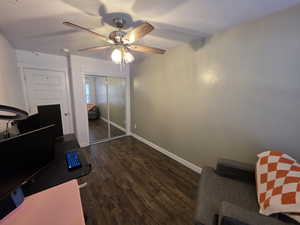 Office with dark wood finished floors and ceiling fan