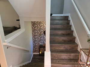 Stairs with wood finished floors and baseboards