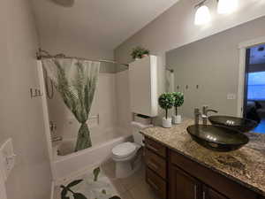 Full bathroom with shower / tub combo, vanity, light tile patterned floors, and a textured ceiling