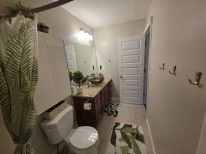 Bathroom featuring vanity, light tile patterned floors, and a shower with shower curtain