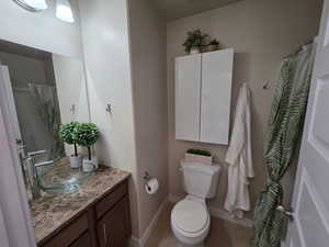 Bathroom featuring a shower with curtain, vanity, and light tile patterned floors