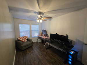Office space featuring dark wood-type flooring and ceiling fan