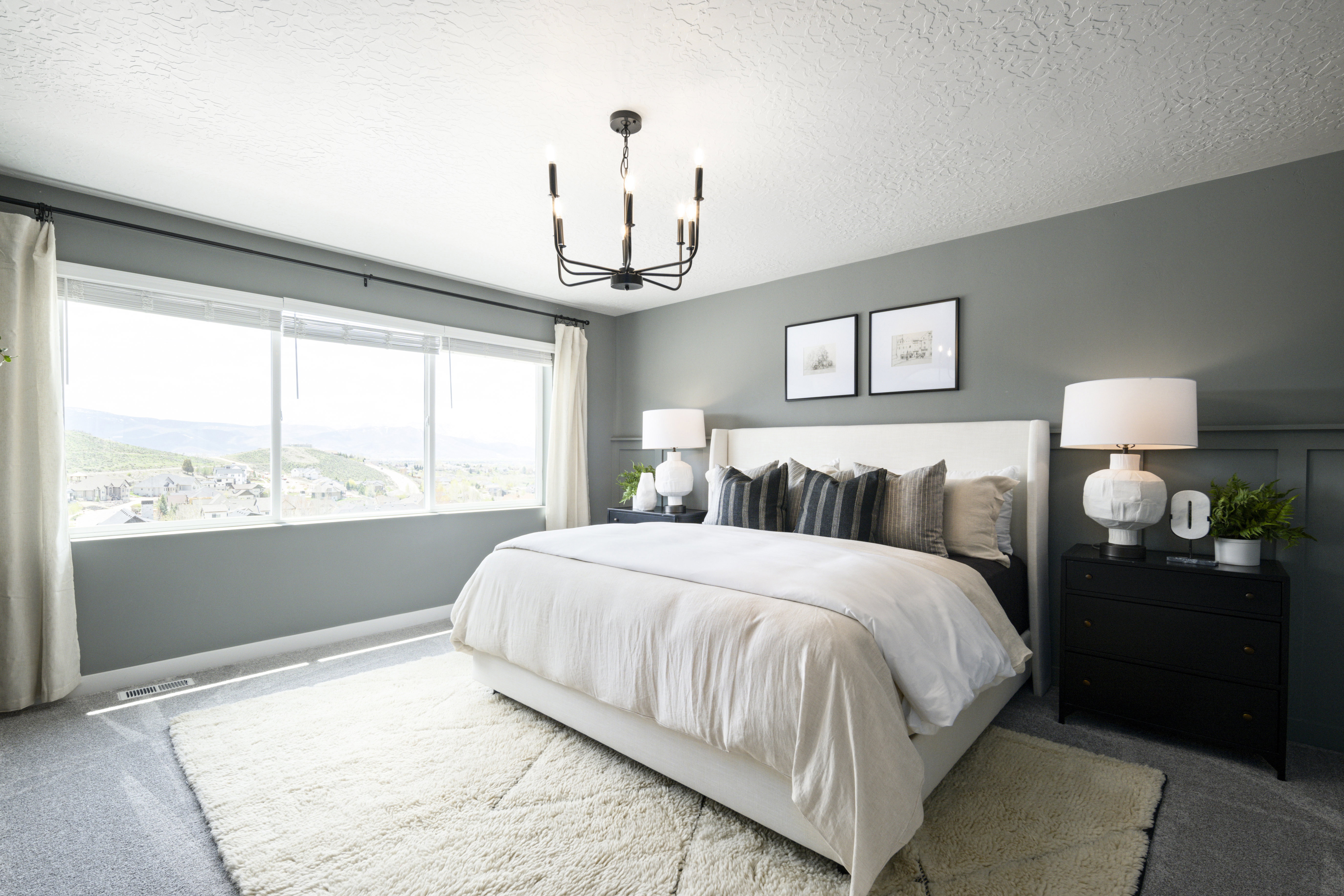 Bedroom featuring carpet, a chandelier, a textured ceiling, and a mountain view