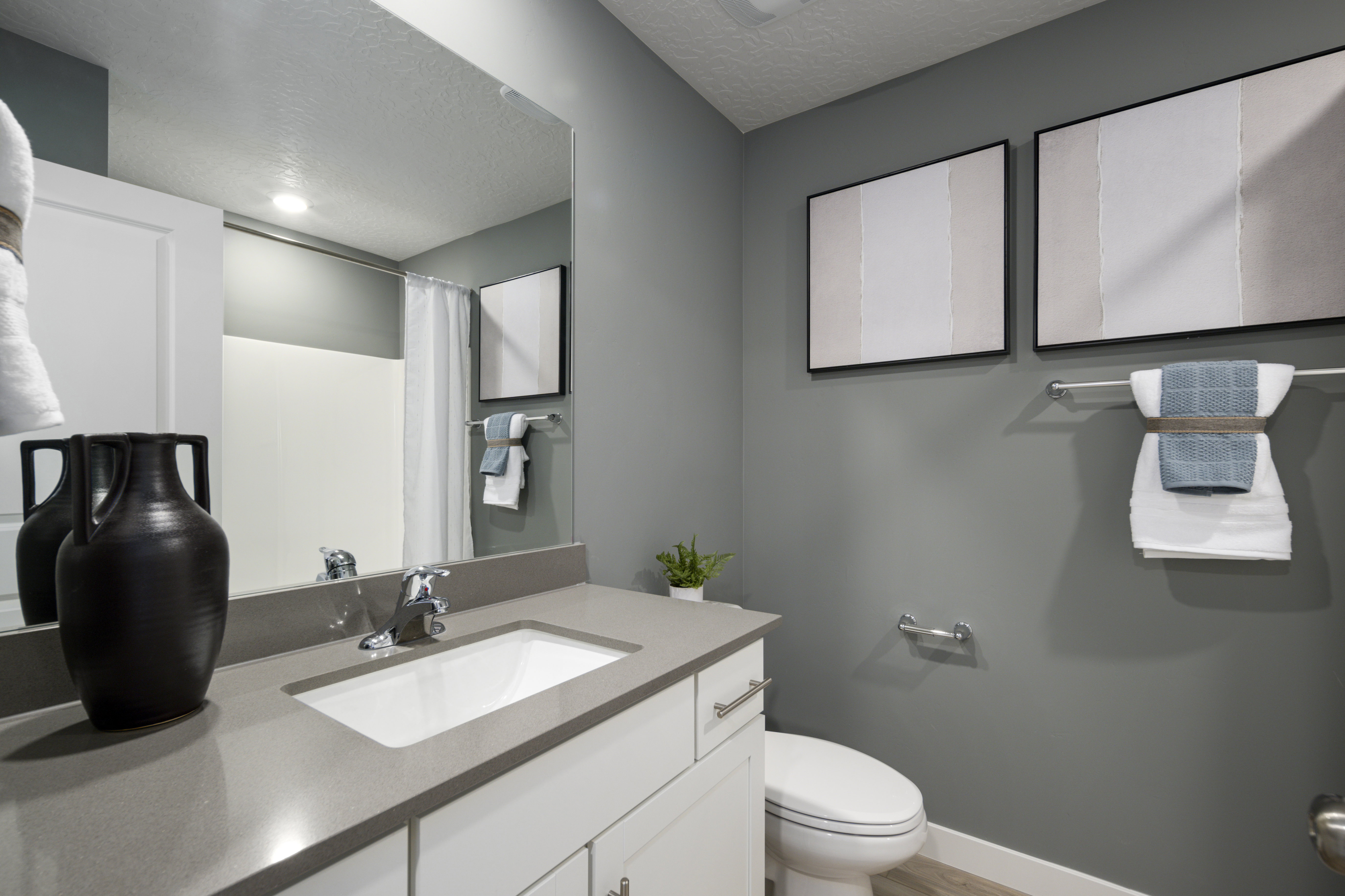 Full bath with vanity, curtained shower, a textured ceiling, and light wood finished floors
