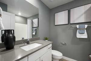 Full bath with vanity, curtained shower, a textured ceiling, and light wood finished floors