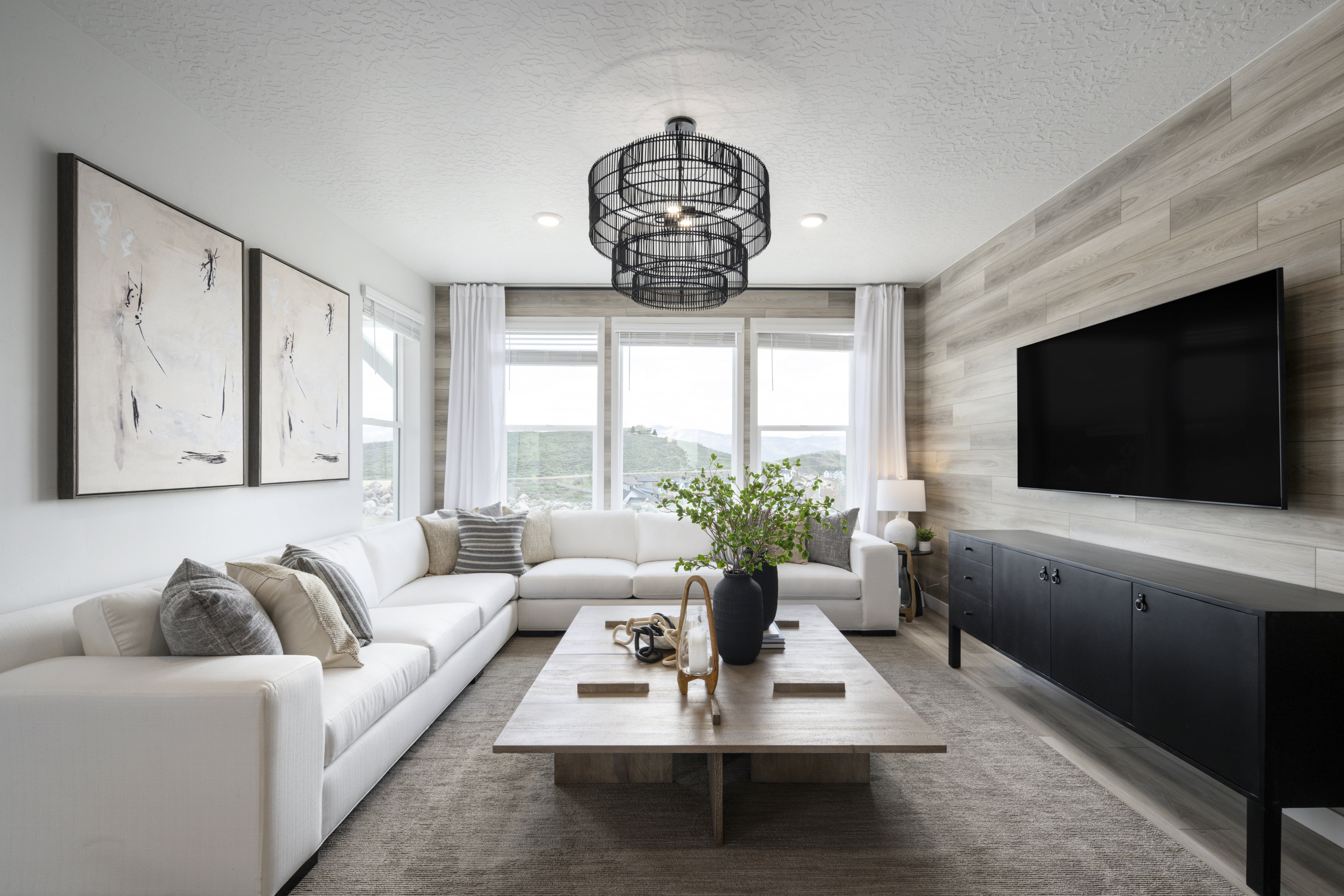 Living room with a textured ceiling, wooden walls, wood finished floors, and recessed lighting