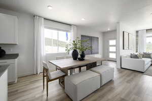 Dining space featuring a textured ceiling, light wood-style flooring, and recessed lighting