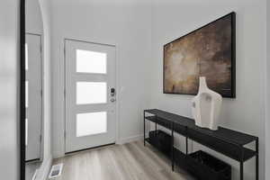 Entrance foyer with light wood-style floors and baseboards
