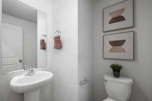 Half bath featuring toilet and a sink