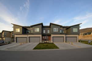 Modern home with driveway, a residential view, and an attached garage