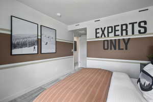 Bedroom with a textured ceiling and carpet