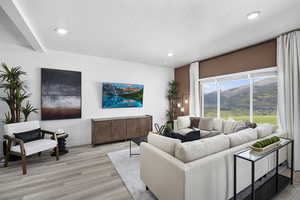 Living area featuring light wood-style flooring, recessed lighting, and a textured ceiling